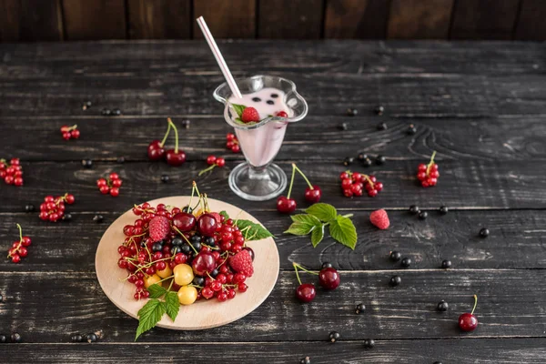 Ahududu, kiraz, frenk üzümü, karanlık bir arka plan karşı ahşap bir tabakta blackcurrant. Arka plan olarak kullanılabilir