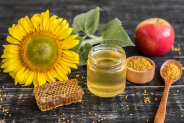 Banka, peteğin ve polen ahşap bir masa üzerinde güzel şeffaf tatlım. Arka plan olarak kullanılabilir