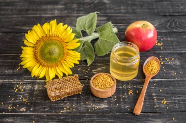 Banka, peteğin ve polen ahşap bir masa üzerinde güzel şeffaf tatlım. Arka plan olarak kullanılabilir