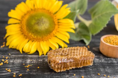 Banka, peteğin ve polen ahşap bir masa üzerinde güzel şeffaf tatlım. Arka plan olarak kullanılabilir
