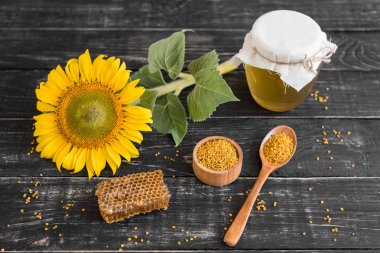 Banka, peteğin ve polen ahşap bir masa üzerinde güzel şeffaf tatlım. Arka plan olarak kullanılabilir