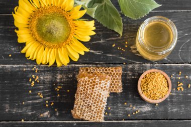 Banka, peteğin ve polen ahşap bir masa üzerinde güzel şeffaf tatlım. Arka plan olarak kullanılabilir