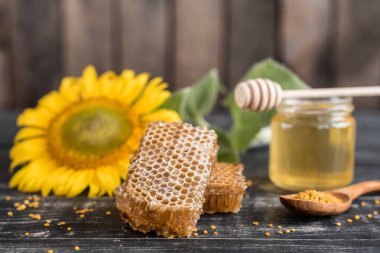 Banka, peteğin ve polen ahşap bir masa üzerinde güzel şeffaf tatlım. Arka plan olarak kullanılabilir