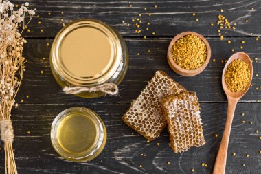 Banka, peteğin ve polen ahşap bir masa üzerinde güzel şeffaf tatlım. Arka plan olarak kullanılabilir