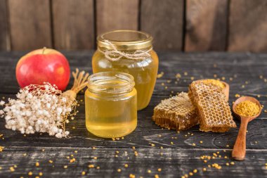 Banka, peteğin ve polen ahşap bir masa üzerinde güzel şeffaf tatlım. Arka plan olarak kullanılabilir