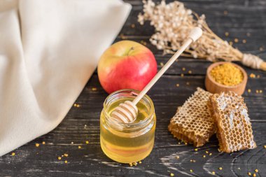 Banka, peteğin ve polen ahşap bir masa üzerinde güzel şeffaf tatlım. Arka plan olarak kullanılabilir