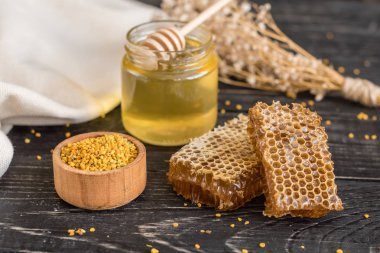 Banka, peteğin ve polen ahşap bir masa üzerinde güzel şeffaf tatlım. Arka plan olarak kullanılabilir