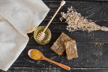 Banka, peteğin ve polen ahşap bir masa üzerinde güzel şeffaf tatlım. Arka plan olarak kullanılabilir