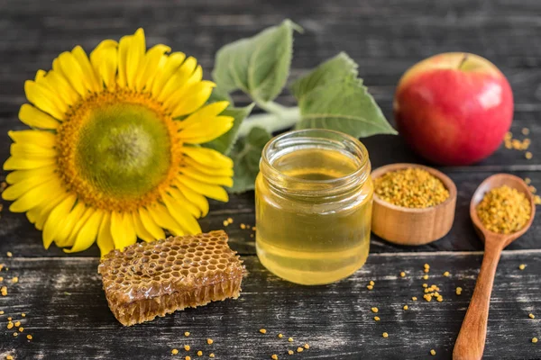 Banka, peteğin ve polen ahşap bir masa üzerinde güzel şeffaf tatlım. Arka plan olarak kullanılabilir