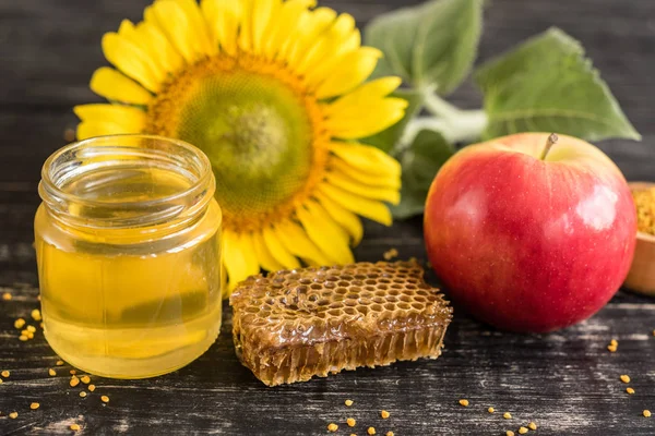 Banka, peteğin ve polen ahşap bir masa üzerinde güzel şeffaf tatlım. Arka plan olarak kullanılabilir