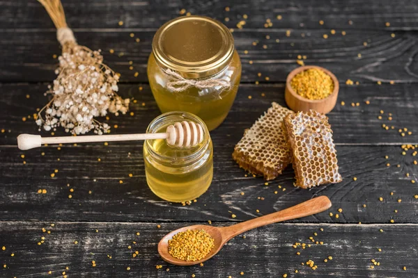 Banka, peteğin ve polen ahşap bir masa üzerinde güzel şeffaf tatlım. Arka plan olarak kullanılabilir