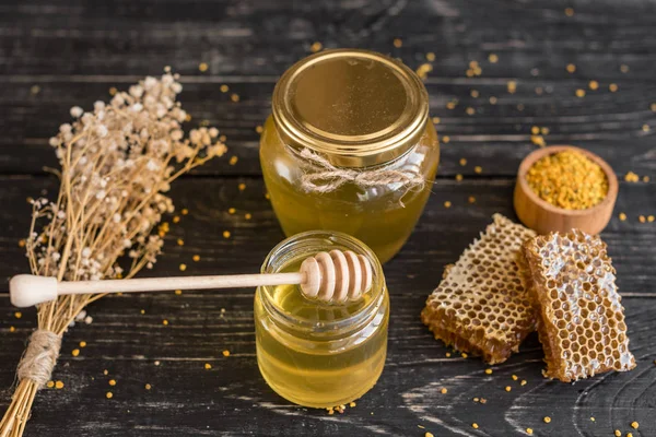 Banka, peteğin ve polen ahşap bir masa üzerinde güzel şeffaf tatlım. Arka plan olarak kullanılabilir