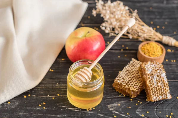 Banka, peteğin ve polen ahşap bir masa üzerinde güzel şeffaf tatlım. Arka plan olarak kullanılabilir