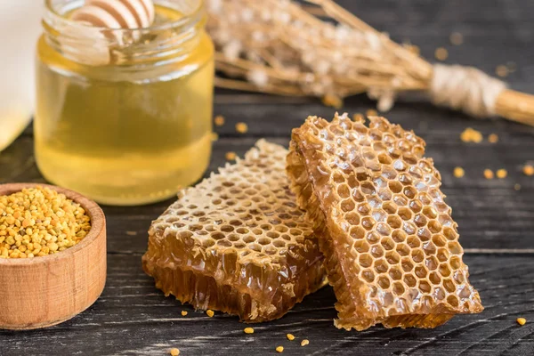 Banka, peteğin ve polen ahşap bir masa üzerinde güzel şeffaf tatlım. Arka plan olarak kullanılabilir