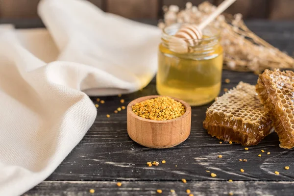 Banka, peteğin ve polen ahşap bir masa üzerinde güzel şeffaf tatlım. Arka plan olarak kullanılabilir