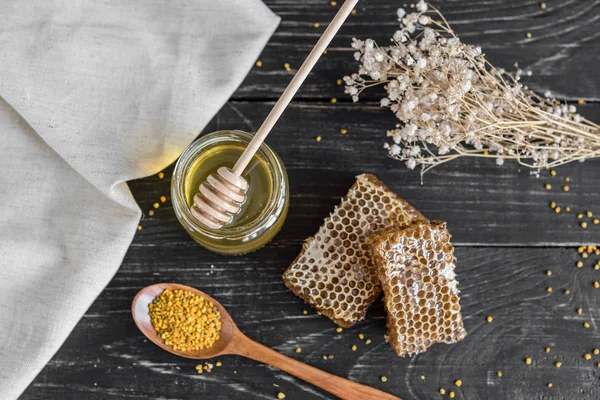 Banka, peteğin ve polen ahşap bir masa üzerinde güzel şeffaf tatlım. Arka plan olarak kullanılabilir