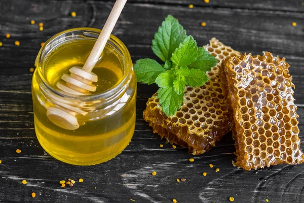 Banka, peteğin ve polen ahşap bir masa üzerinde güzel şeffaf tatlım. Arka plan olarak kullanılabilir