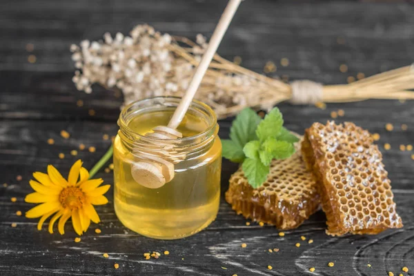 Banka, peteğin ve polen ahşap bir masa üzerinde güzel şeffaf tatlım. Arka plan olarak kullanılabilir