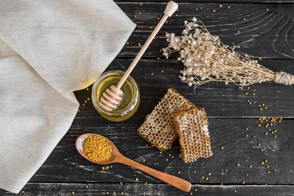 Banka, peteğin ve polen ahşap bir masa üzerinde güzel şeffaf tatlım. Arka plan olarak kullanılabilir