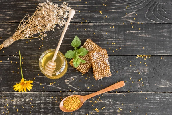 Banka, peteğin ve polen ahşap bir masa üzerinde güzel şeffaf tatlım. Arka plan olarak kullanılabilir