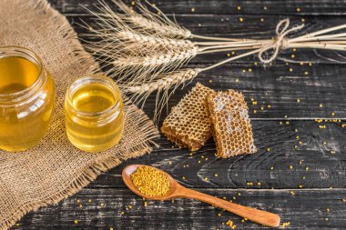 Banka, peteğin ve polen ahşap bir masa üzerinde güzel şeffaf tatlım. Arka plan olarak kullanılabilir