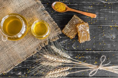 Banka, peteğin ve polen ahşap bir masa üzerinde güzel şeffaf tatlım. Arka plan olarak kullanılabilir