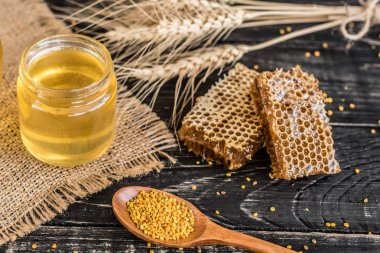 Banka, peteğin ve polen ahşap bir masa üzerinde güzel şeffaf tatlım. Arka plan olarak kullanılabilir