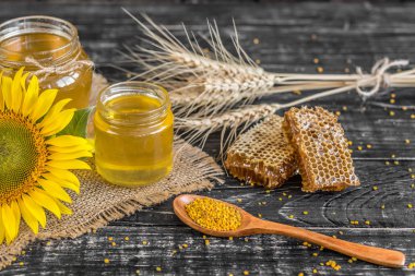 Banka, peteğin ve polen ahşap bir masa üzerinde güzel şeffaf tatlım. Arka plan olarak kullanılabilir