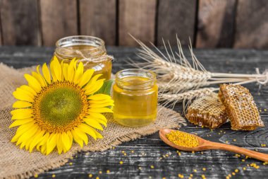 Banka, peteğin ve polen ahşap bir masa üzerinde güzel şeffaf tatlım. Arka plan olarak kullanılabilir