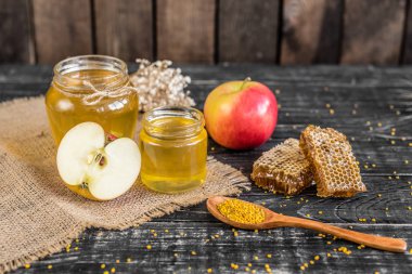 Banka, peteğin ve polen ahşap bir masa üzerinde güzel şeffaf tatlım. Arka plan olarak kullanılabilir