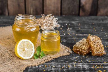 Banka, peteğin ve polen ahşap bir masa üzerinde güzel şeffaf tatlım. Arka plan olarak kullanılabilir