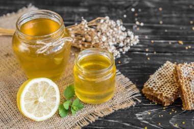 Banka, peteğin ve polen ahşap bir masa üzerinde güzel şeffaf tatlım. Arka plan olarak kullanılabilir