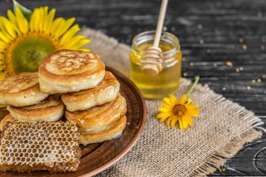 Banka, peteğin ve polen ahşap bir masa üzerinde güzel şeffaf tatlım. Arka plan olarak kullanılabilir