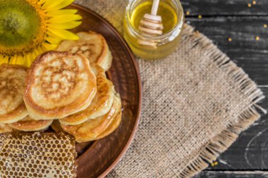 Banka, peteğin ve polen ahşap bir masa üzerinde güzel şeffaf tatlım. Arka plan olarak kullanılabilir