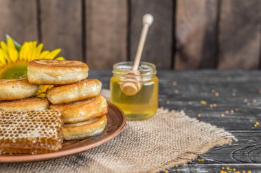Banka, peteğin ve polen ahşap bir masa üzerinde güzel şeffaf tatlım. Arka plan olarak kullanılabilir