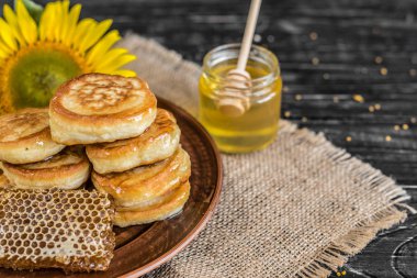 Banka, peteğin ve polen ahşap bir masa üzerinde güzel şeffaf tatlım. Arka plan olarak kullanılabilir