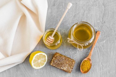 Banka, peteğin ve polen ahşap bir masa üzerinde güzel şeffaf tatlım. Arka plan olarak kullanılabilir