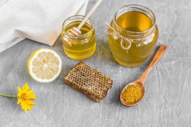 Banka, peteğin ve polen ahşap bir masa üzerinde güzel şeffaf tatlım. Arka plan olarak kullanılabilir