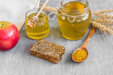 Banka, peteğin ve polen ahşap bir masa üzerinde güzel şeffaf tatlım. Arka plan olarak kullanılabilir