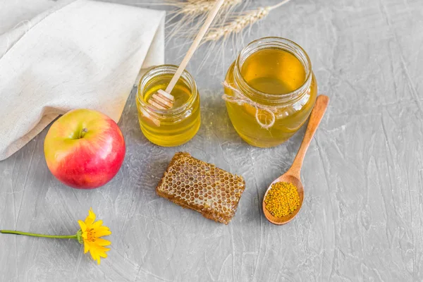 Banka, peteğin ve polen ahşap bir masa üzerinde güzel şeffaf tatlım. Arka plan olarak kullanılabilir