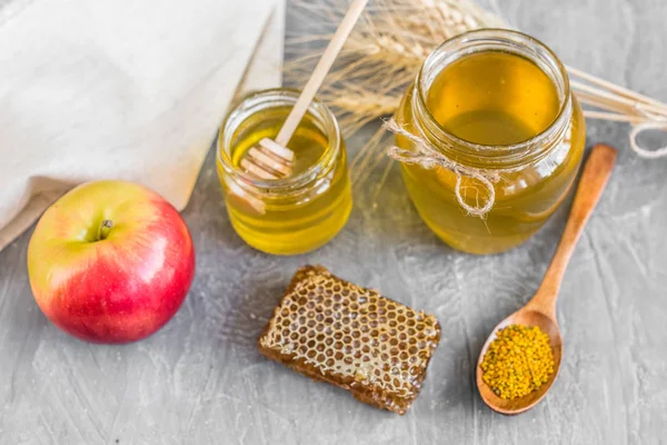 Banka, peteğin ve polen ahşap bir masa üzerinde güzel şeffaf tatlım. Arka plan olarak kullanılabilir