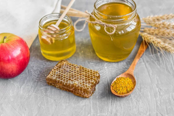 Banka, peteğin ve polen ahşap bir masa üzerinde güzel şeffaf tatlım. Arka plan olarak kullanılabilir