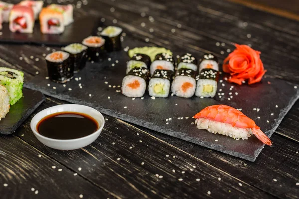 Fresh and tasty sushi on dark background. It can be used as a background