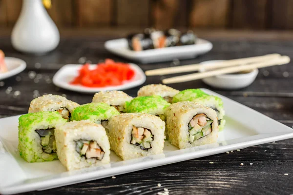 Fresh and tasty sushi on dark background. It can be used as a background