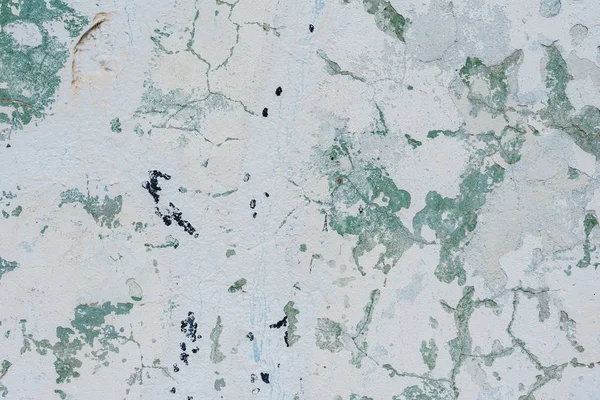 Çizik ve çatlaklarla dolu bir duvar parçası.