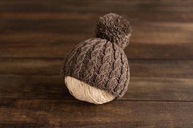 Koyu ahşap arka plan üzerine kumaş ve örme çocuk şapkası