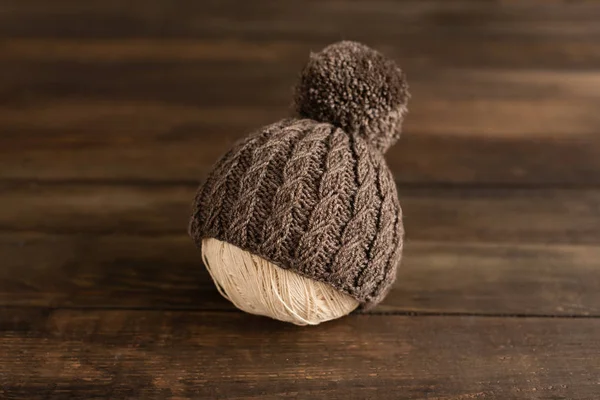 Gestrickte Kindermütze Und Stoffe Auf Dunklem Holzgrund — Stockfoto