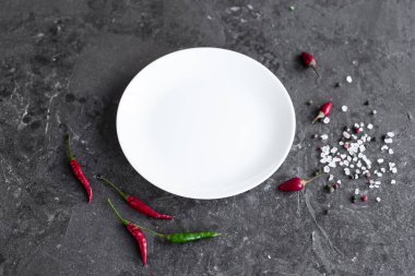 Gri beton zemin üzerine beyaz tabak. Yemek pişirmek için hazırlık. Arka plan olarak kullanılabilir