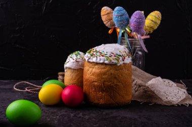 Paskalya, pasta, yumurta, tatil. Paskalya kek ve karanlık bir arka plan üzerinde renkli yumurta. Arka plan olarak kullanılabilir