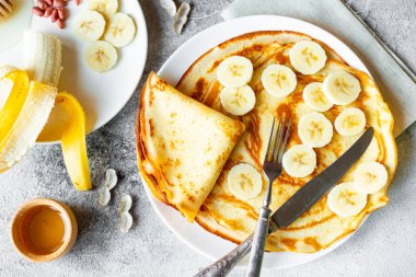 Yemek, tatlı, hamur işleri, krep, börek. Lezzetli güzel krep muz ve ballı bir beton zemin üzerine